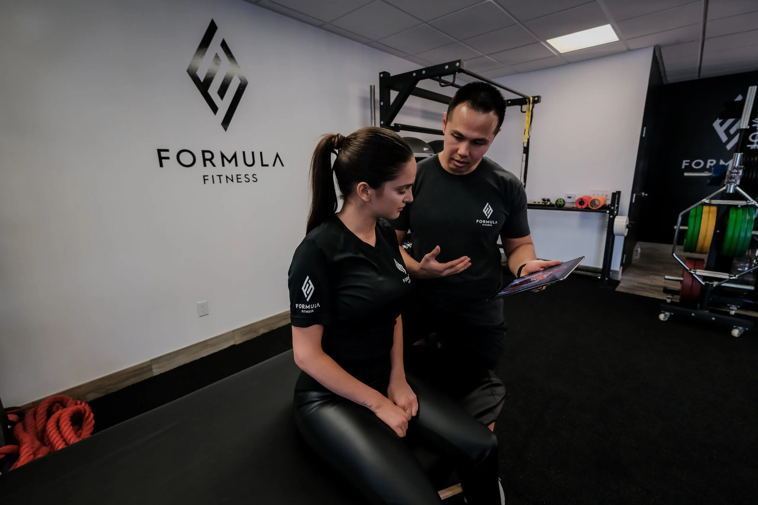 Two fitness coaches in gym smiling